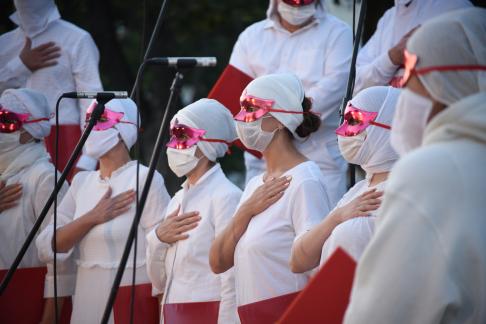 fotografia: zdjecie kilku osób w biało-czerwonych strojach i biało-czerwonymi maskami na twarzy