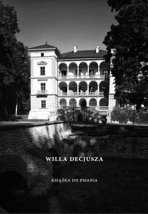 A photograph of a cover of the book titled Książka do pisania. Willa Decjusza. On the cover a black and white picture of the front side of the villa