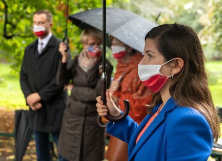 Fotografia. Ludzie pod parasolami podczas otwarcia wystawy plenerowej na krakowskich plantach.
