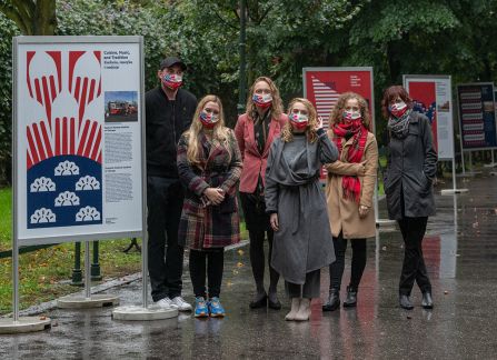 A photograph. An opening of the outdoor exhibition titled Polish Americans, American poles at planty in Krakow. the organisers and curators of the exhibition pose in front of the posters.